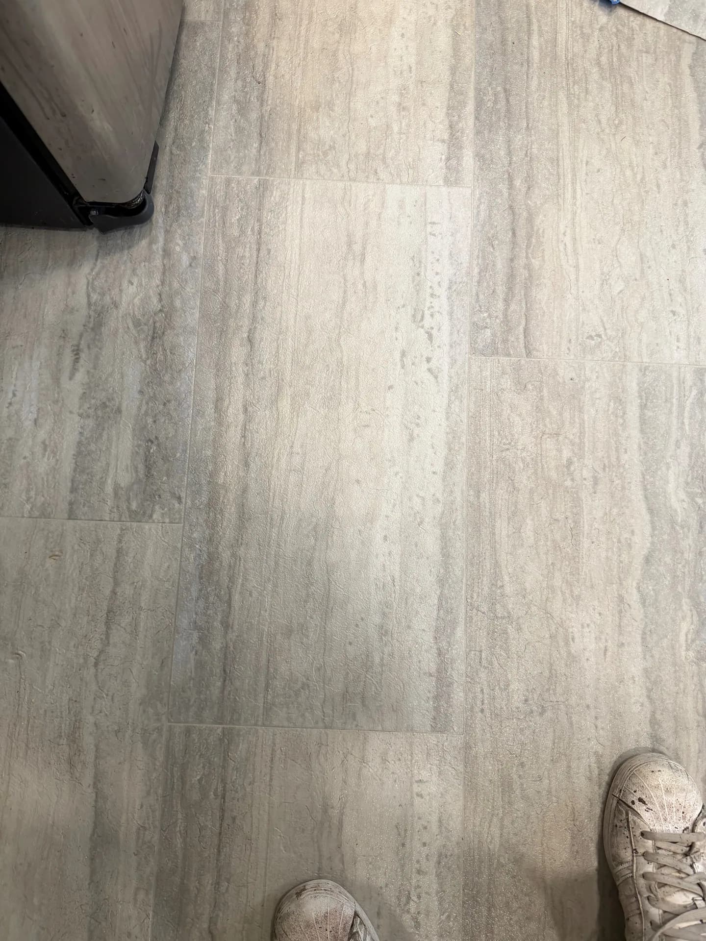 Repaired gray stone-look sheet vinyl in Bristol, CT, with the printed tile pattern intact and the earlier lifted tear edges no longer visible.