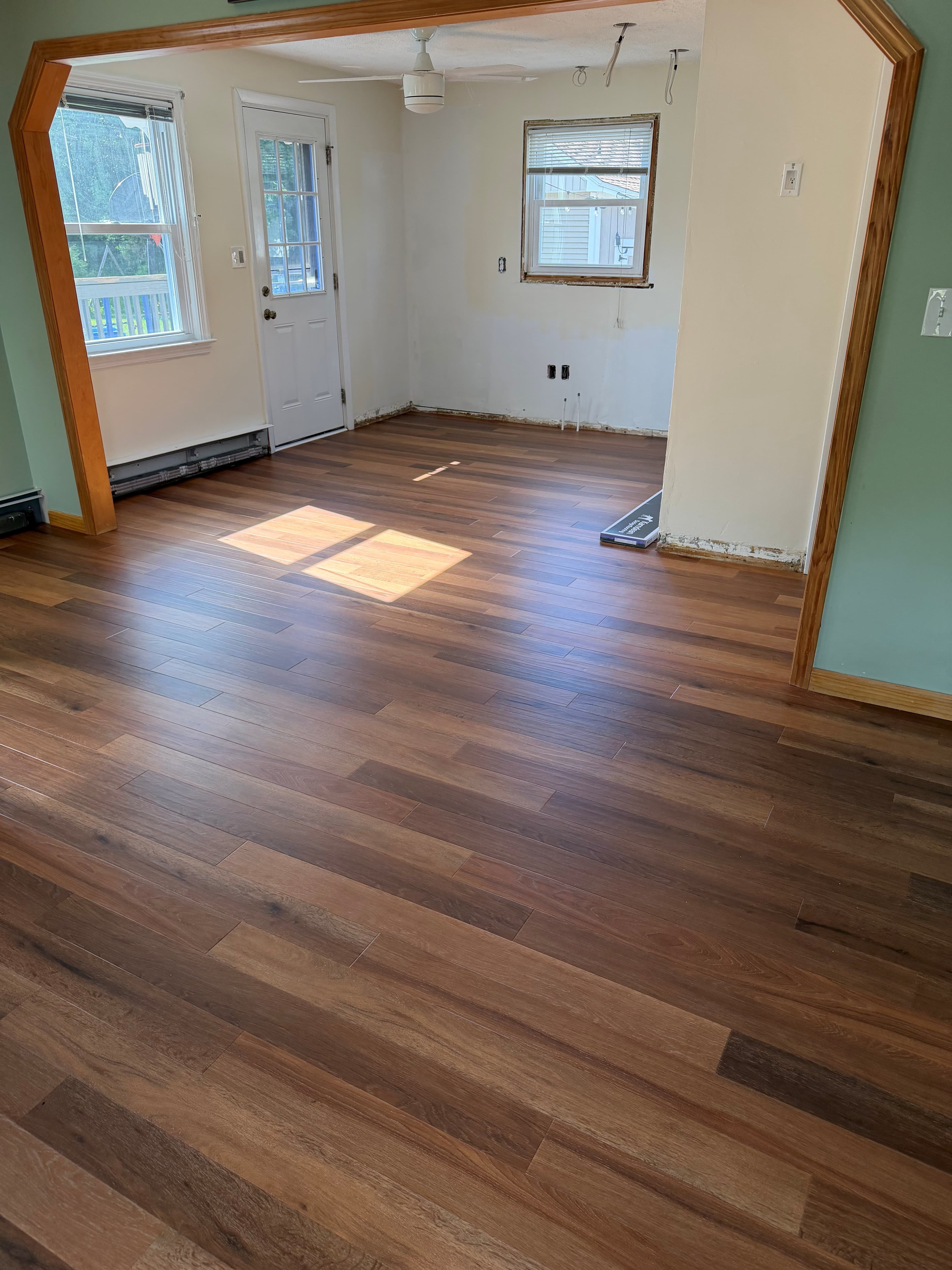 Finished open living area with rich brown wood-look plank flooring