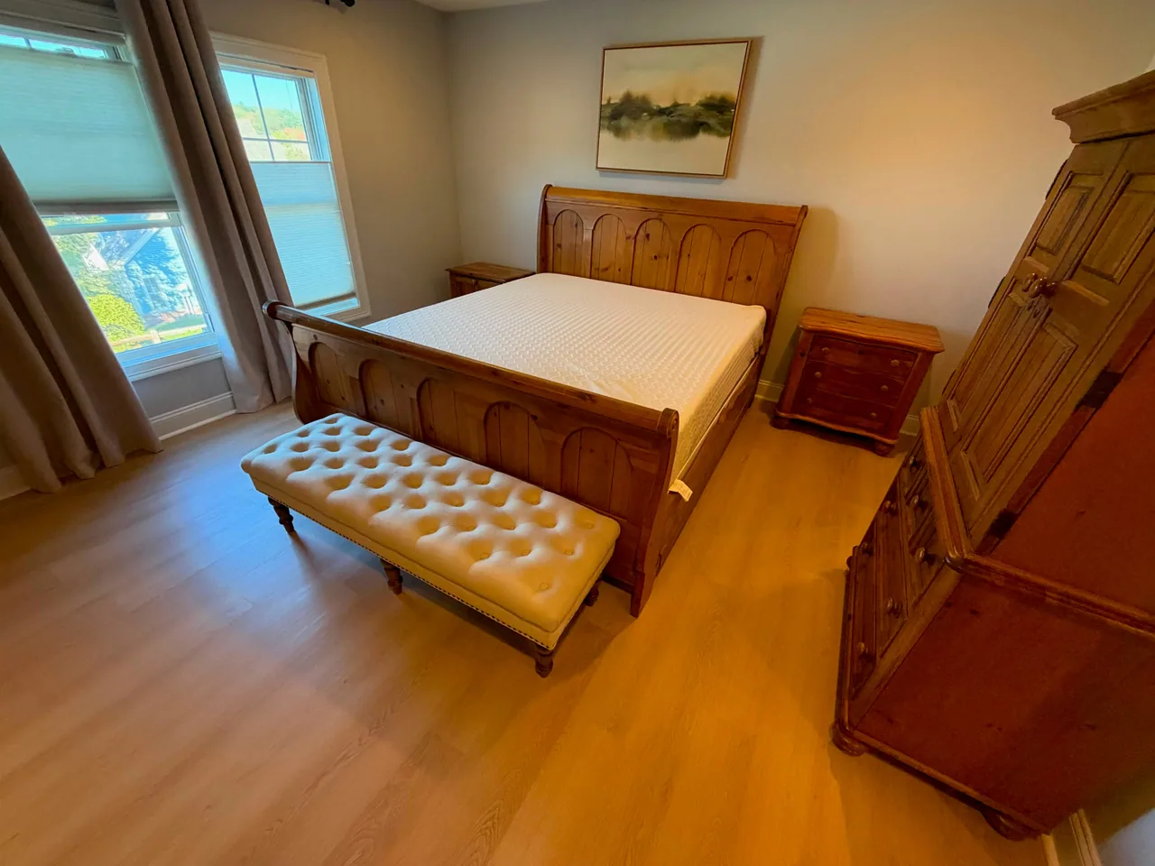 Light wood-look plank flooring around a wooden bed and bedroom furniture.