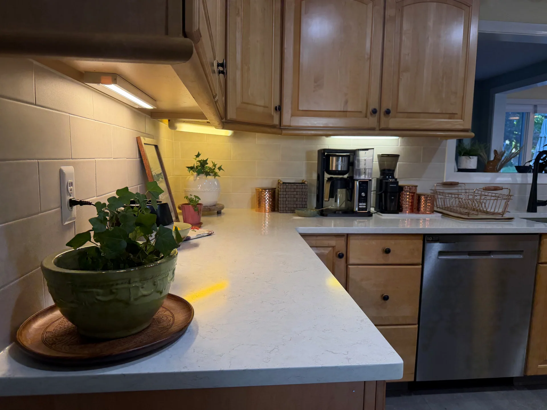 Finished light-colored tile backsplash along the kitchen corner beside a coffee station.
